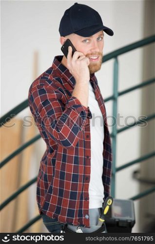 tradesman entering premises talking on his smartphone