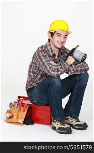 Tradesman holding a blowtorch and sitting on his toolbox