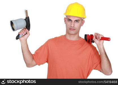 Tradesman holding a pipe wrench and a blowtorch