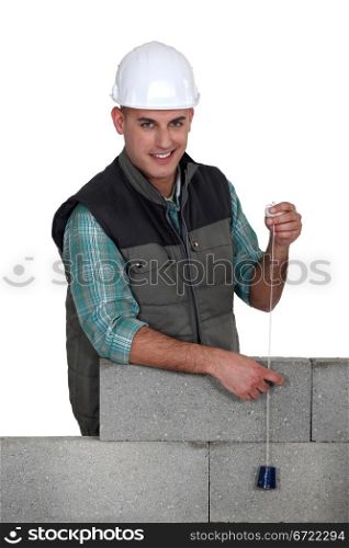 Tradesman holding a plumbline