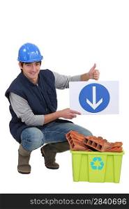 Tradesman holding a sign pointing to a recycling bin
