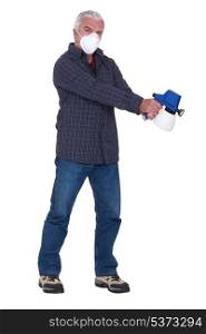 Tradesman holding a spray gun and wearing a mask