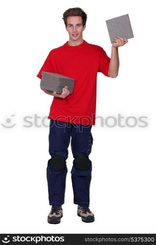 Tradesman holding a stack of tiles