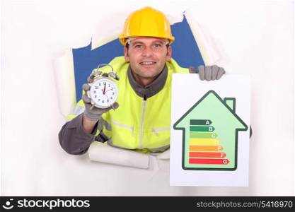 Tradesman holding an energy efficiency rating chart and an alarm clock