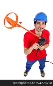 Tradesman holding up a tool for mixing mortar