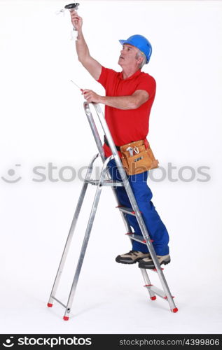 Tradesman installing a light fixture