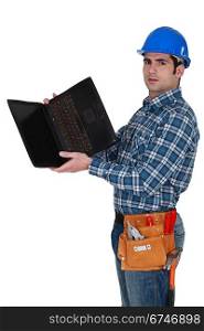 Tradesman looking at the underside of his laptop