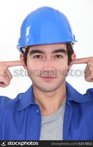 Tradesman plugging his ears