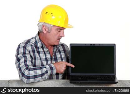 Tradesman pointing to his new laptop