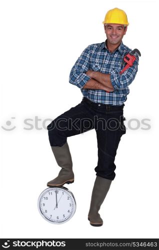 Tradesman stood by a clock