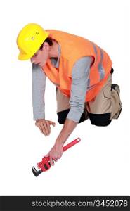 Tradesman using a pipe wrench
