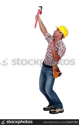 Tradesman using a pipe wrench to tighten an object