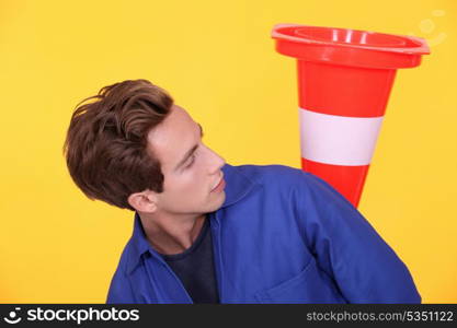 Tradesman with a traffic cone