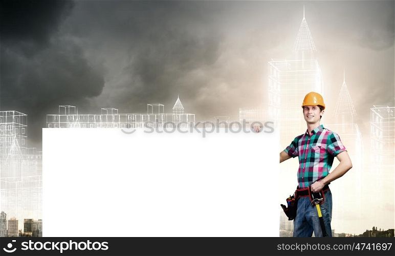 Tradesman with banner. Young repairman holding white blank banner. Place for text