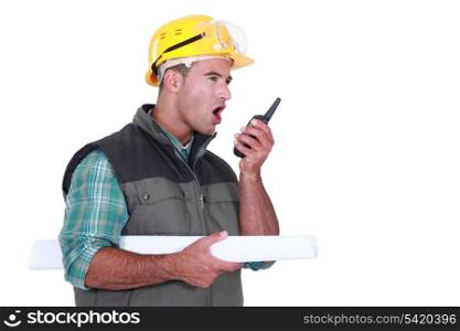 Tradesman yelling into a walkie-talkie