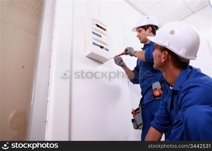 Tradesmen installing a distribution board