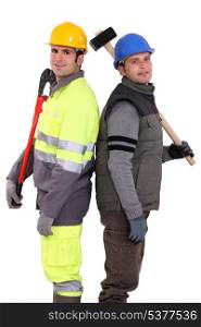 Tradesmen standing back to back and holding tools