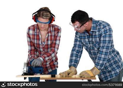 Tradespeople cutting a wooden plank with a circular saw