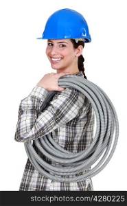 Tradeswoman carrying corrugated tubing