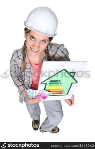 Tradeswoman holding an energy efficiency rating sign and a wad of money