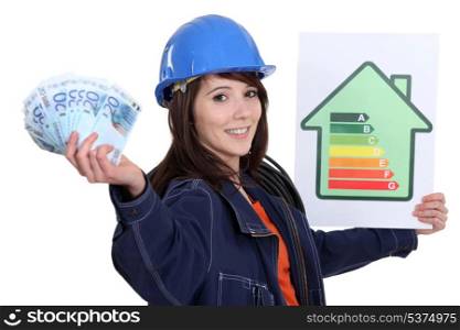 Tradeswoman holding up an energy efficiency rating chart and a wad of money
