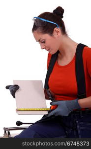 Tradeswoman measuring a tile