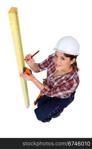 Tradeswoman using a measuring tape