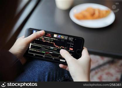 trading online on smartphone with business woman hand