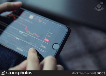 trading online on smartphone with business woman hand