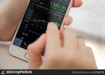 trading online on smartphone with bussiness woman hand