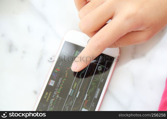 trading online on smartphone with bussiness woman hand