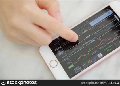 trading online on smartphone with bussiness woman hand