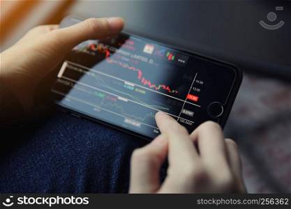 trading online on smartphone with bussiness woman hand