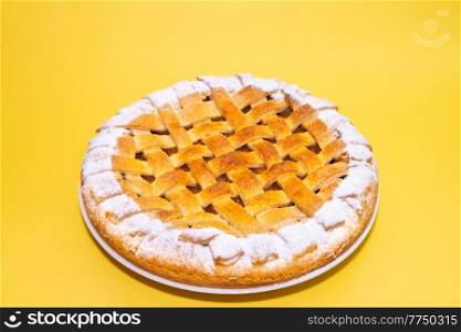 Tradition american apple pie with sugar crust on yellow background