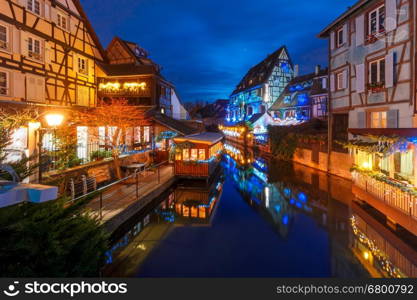 Traditional Alsatian half-timbered houses and river Lauch in Petite Venise or little Venice, old town of Colmar, decorated and illuminated at christmas time, Alsace, France