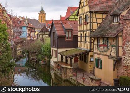 Traditional Alsatian half-timbered houses, church and river Lauch in Petite Venise or little Venice, old town of Colmar, decorated at christmas time, Alsace, France. Christmas Little Venice in Colmar, Alsace, France