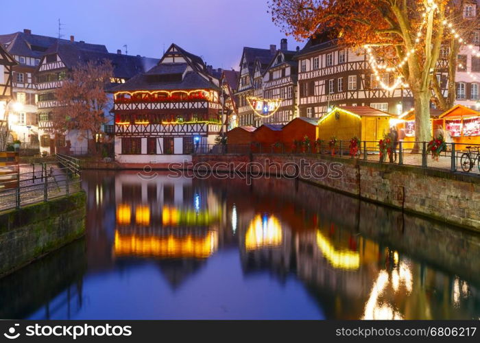 Traditional Alsatian half-timbered houses with mirror reflections in Petite France during twilight blue hour, Strasbourg, Alsace, France