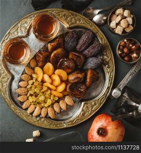 Traditional arabic tea and dry fruits and nuts, flat lay, space for text