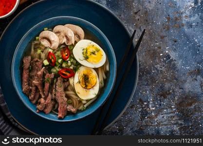 Traditional Asian cuisine. Ramen soup with beef, mushrooms and egg.