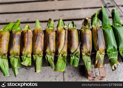 Traditional asian dessert made from rice dough and sweet coconut wrapped in banana leaf