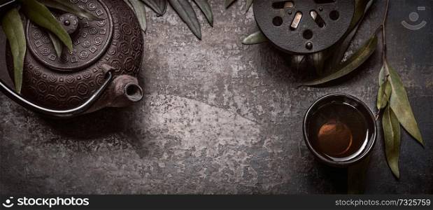 Traditional Asian green tea set with teapot and cups and candle on dark rustic background with copy space, banner or template, top view