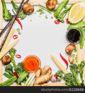 Traditional asian vegetables cooking ingredients with soy sauce and chopsticks. Chinese or Thai food on white chalkboard background, top view, frame
