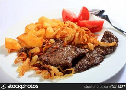 Traditional Austrian zweibelrostbraten, beef escalope with crispy fried onions, served with diced deep fried potatoes. The easily made meal is popular in Central European countries including Austria and Hungary.