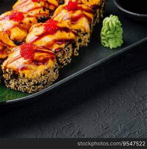Traditional baked japanese sushi on black plate