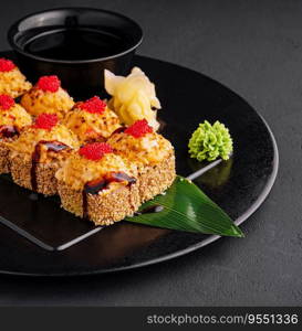 Traditional baked japanese sushi on black plate