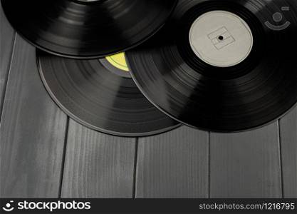 Traditional black vinyl records on gray wooden table