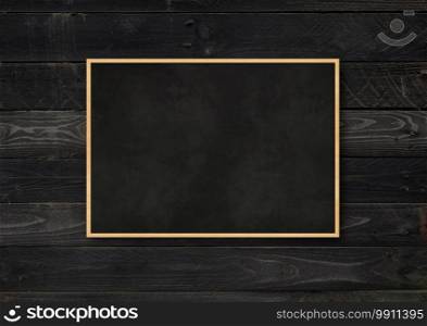Traditional blackboard isolated on a black wood background. Blank horizontal mockup template. Traditional blackboard isolated on a black wood background