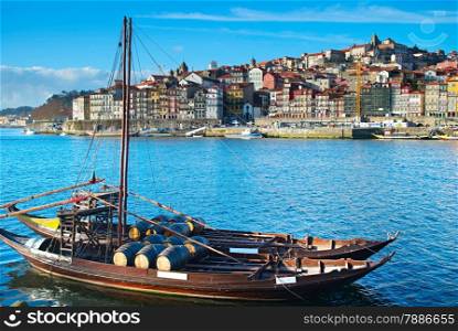 Traditional boat with wine barrels. Porto Old Town on the background. Portugal