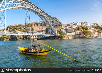 Traditional boats with wine barrels and Douro River in Porto in a beautiful summer day, Portugal