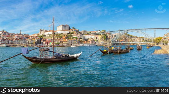 Traditional boats with wine barrels and Douro River in Porto in a beautiful summer day, Portugal